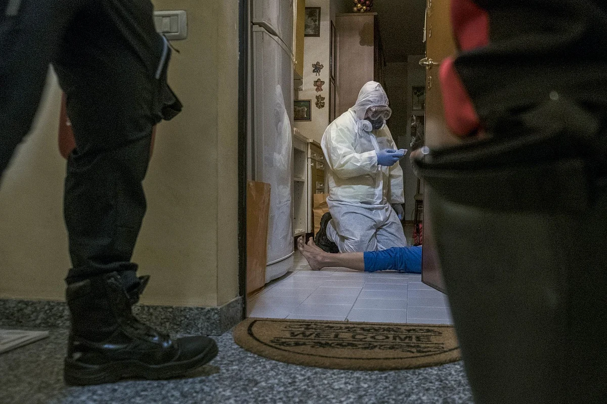 A medical worker on patrol with police in Milan checks a person’s temperature on April 11. Photographer: Gianmarco Maraviglia/Bloomberg
