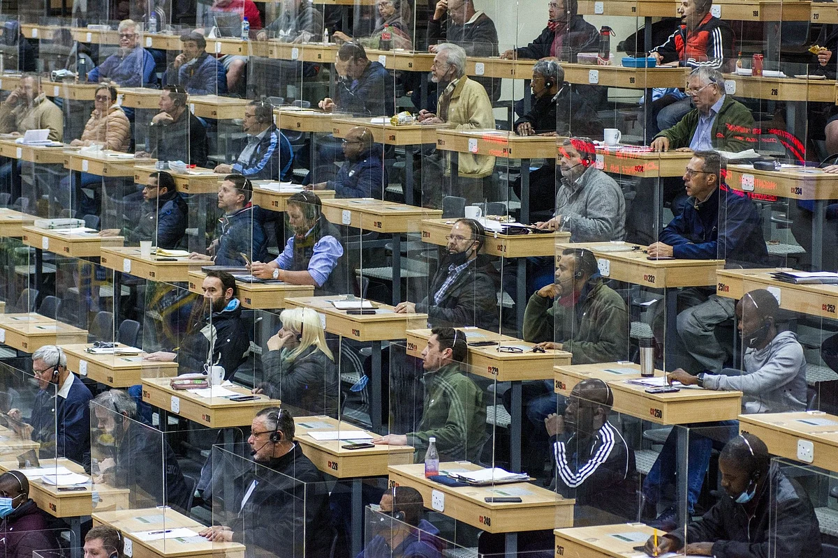 Customers sit behind plastic partitions at a flower market auction in Johannesburg on Aug. 25. Photographer: Waldo Swiegers/Bloomberg