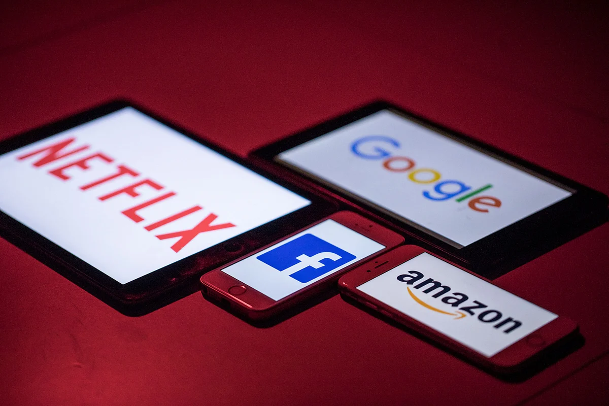 The logos for Facebook, Amazon, Netflix, and Google on smartphone and tablet devices. (Photographer: Jason Alden/Bloomberg)