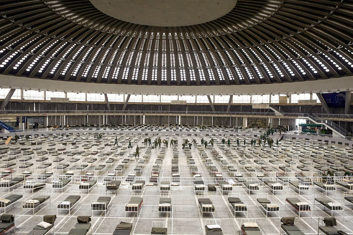 Serbian military personnel set up beds for Covid-19 patients at an exhibition center in Belgrade on March 24. Photographer: Oliver Bunic/Bloomberg