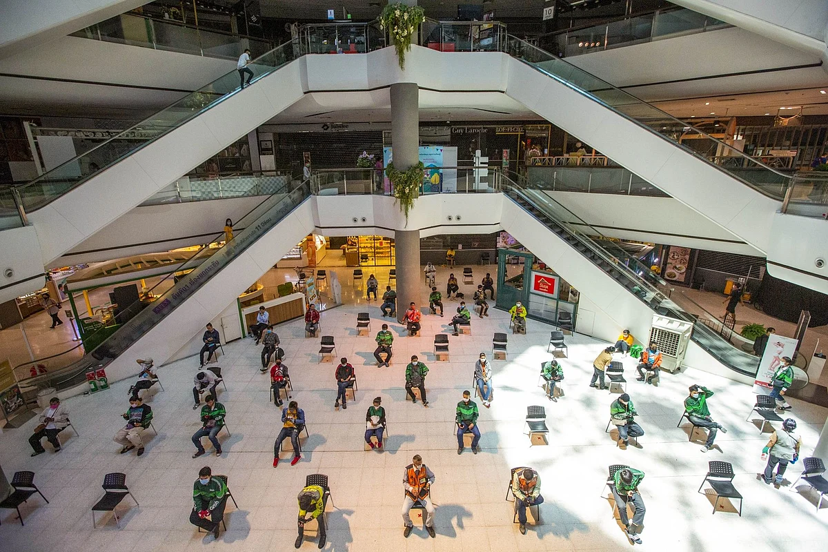 Food delivery couriers wait in a mall in Bangkok on March 30. As Covid-19 lockdowns fell into place all over the world, home delivery of goods and services skyrocketed. Photographer: Andre Malerba/Bloomberg