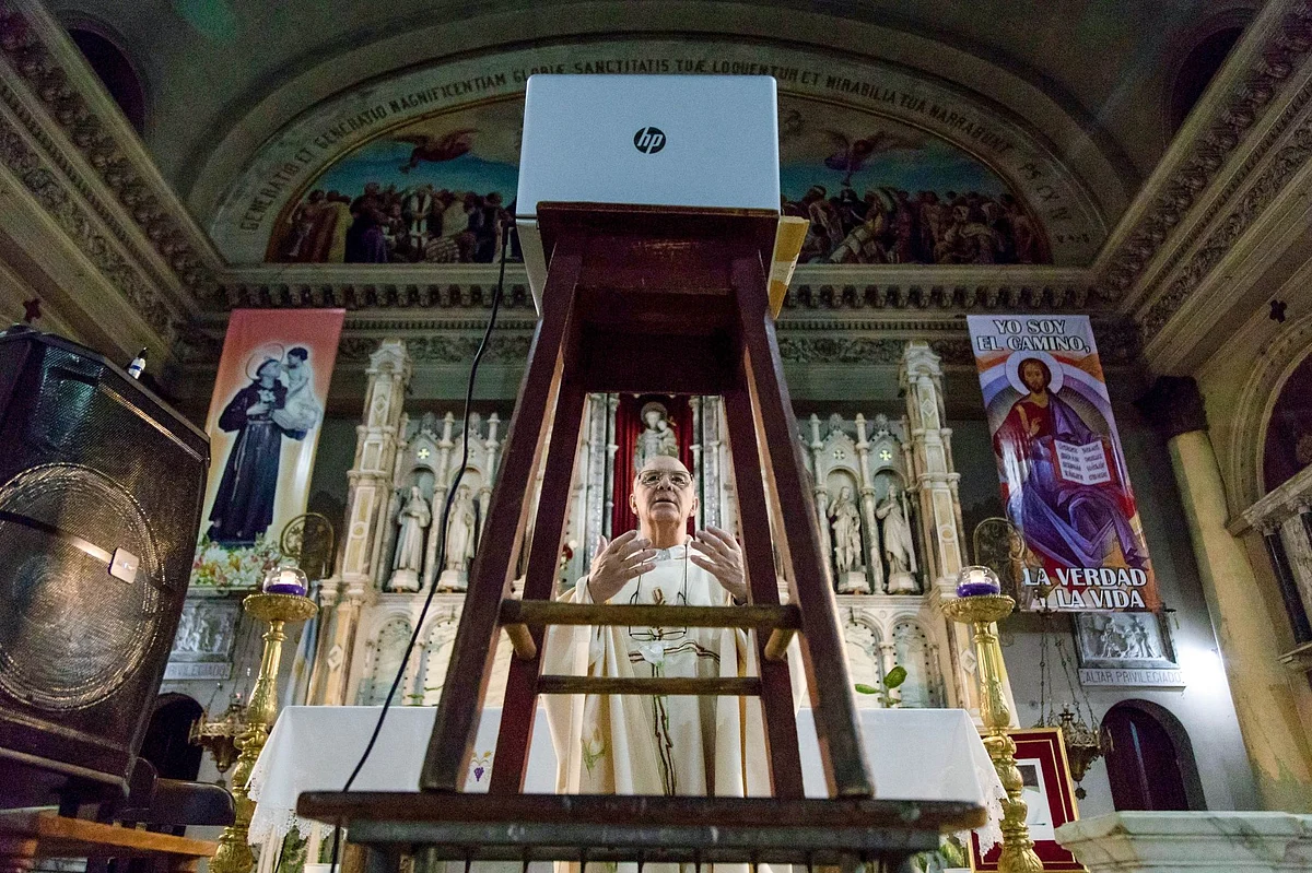 A priest livestreams a Holy Week mass at the empty San Antonio de Padua Church in Buenos Aires, Argentina, on April 9. Photographer: Anita Pouchard Serra/Bloomberg 
