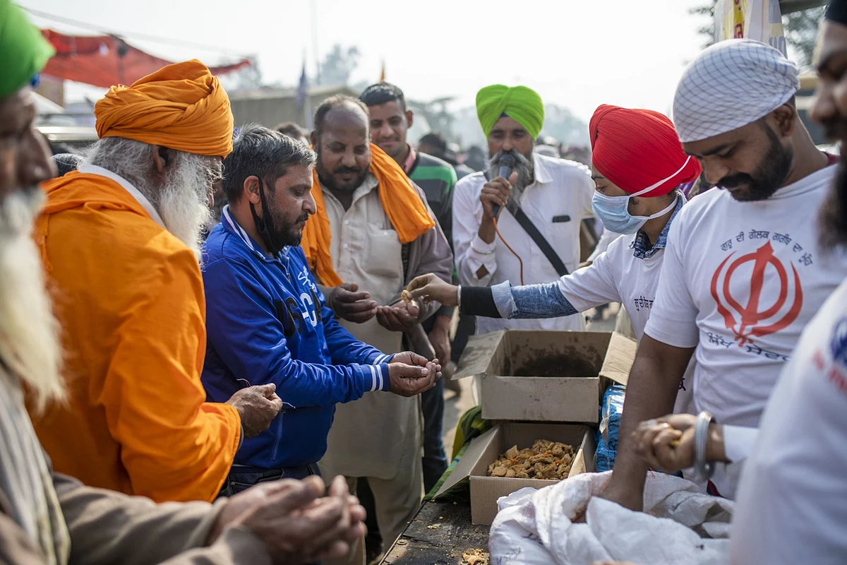 Farmers distribute food at a protest site at a road block on the Delhi-Haryana border crossing in Singhu, Delhi, India. (Photographer: Prashanth Vishwanathan/Bloomberg)