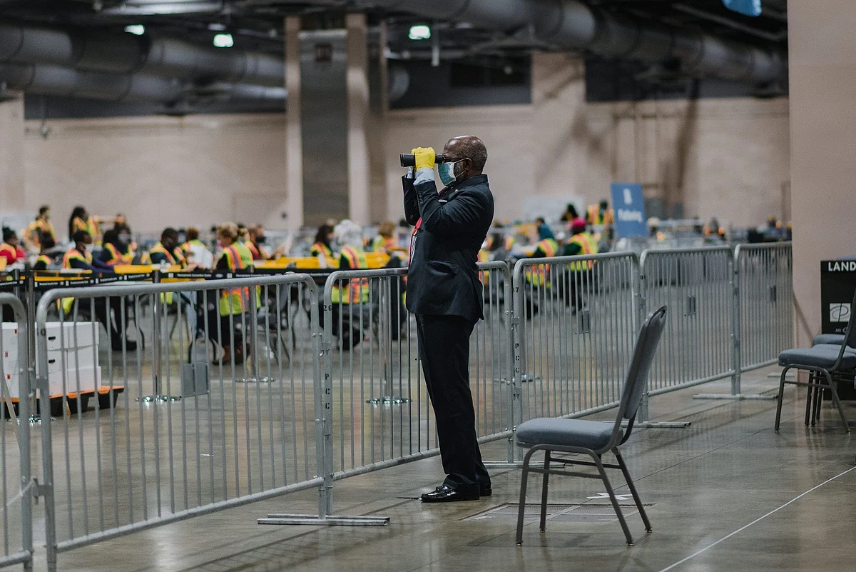 In Philadelphia, a poll watcher uses binoculars to monitor the count in the U.S. presidential election that took place on Nov. 3. Photographer: Hannah Yoon/Bloomberg 