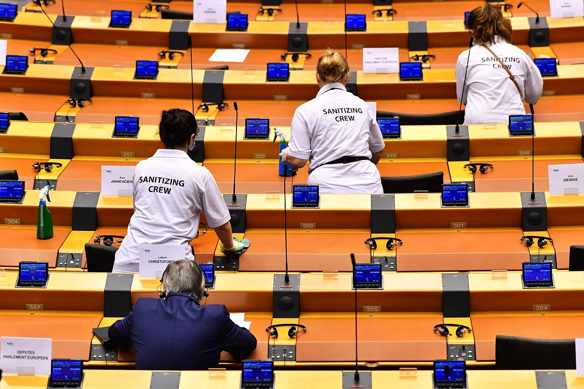 A sanitizing crew cleans desks at the European Parliament in Brussels on July 8. Photographer: Geert Vanden Wijngaert/Bloomberg 