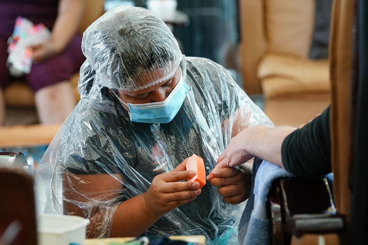 A nail salon worker giving a manicure in Atlanta on April 24. Personal care services have been especially hard hit by the pandemic. Photographer: Elijah Nouvelage/Bloomberg