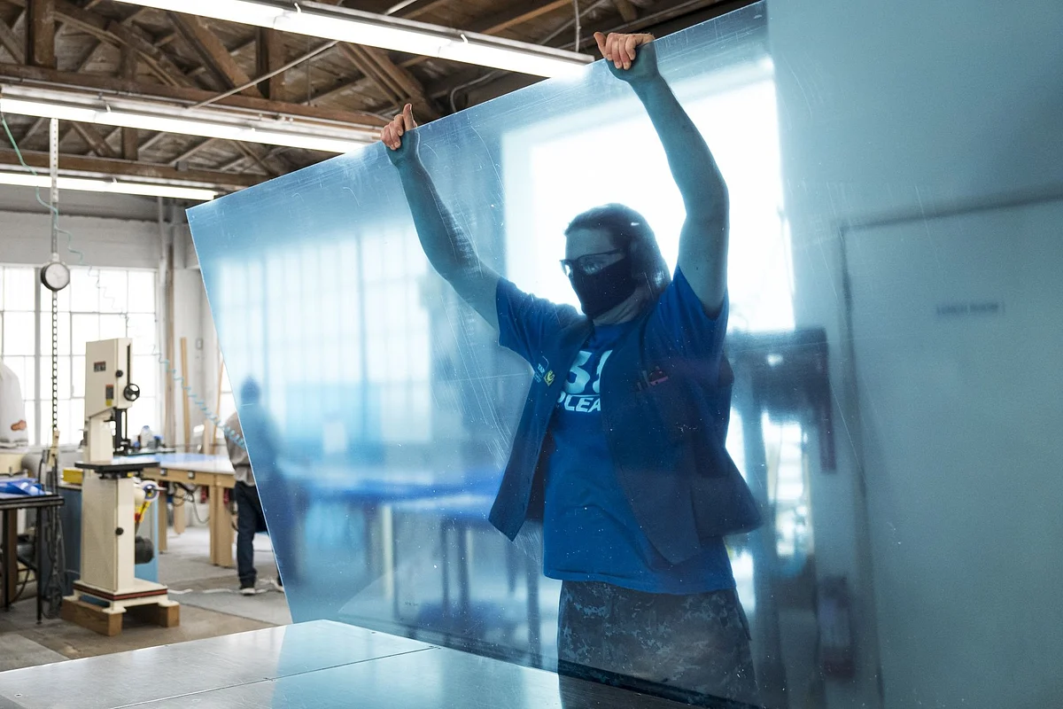 A worker builds a plexiglass guard in San Francisco on May 18. Employers hoping to get people back in the office have been preparing with divided workstations and other precautions to avoid coronavirus transmission. Photographer: David Paul Morris/Bloomberg 