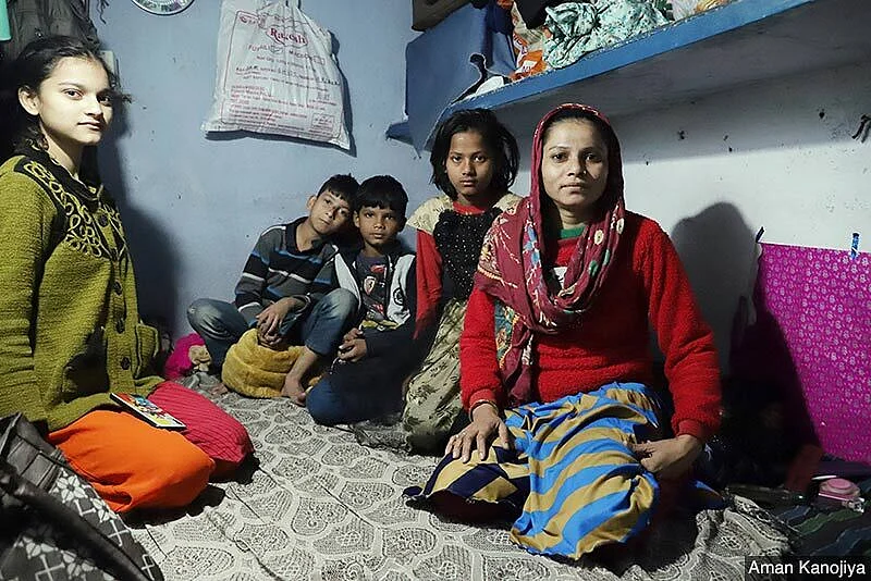 Mehar-un-Nissa sitting with her and a neighbour’s children in her home in Delhi’s Okhla. She moved to the capital from Bihar’s Motihari district few years ago in hope of a better life for her family. She found work in a garment factory and barely manages to scrape through the month. 