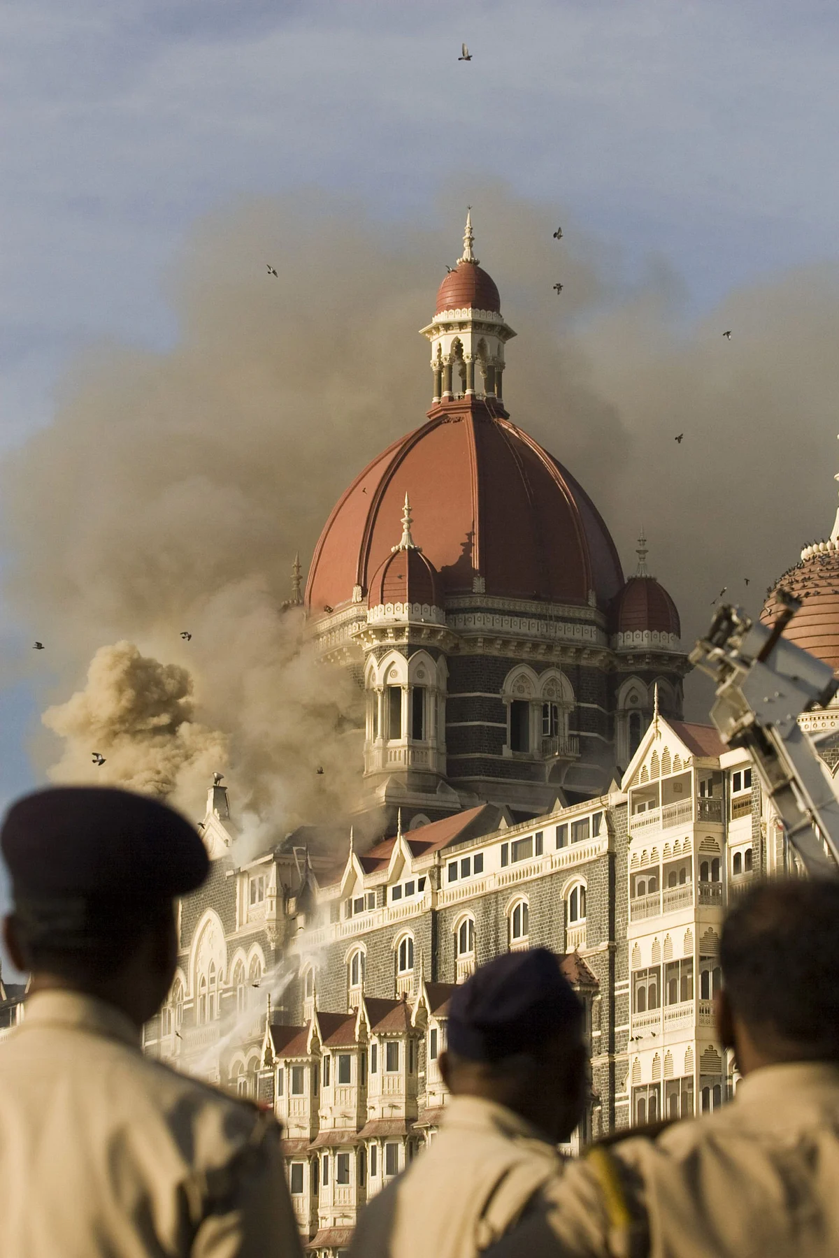 Security forces personnel watch as a fire rages in the Taj Mahal Palace and Tower hotel in Mumbai, India, in 2008 (Photographer: Prashanth Vishwanathan/Bloomberg)