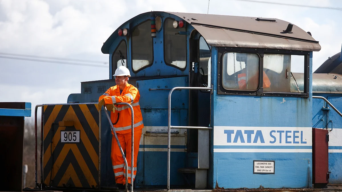 Employees stand on a train loaded with steel coils at the steel works operated by Tata Steel Ltd. in Port Talbot, U.K. (Photographer: Chris Ratcliffe/Bloomberg)