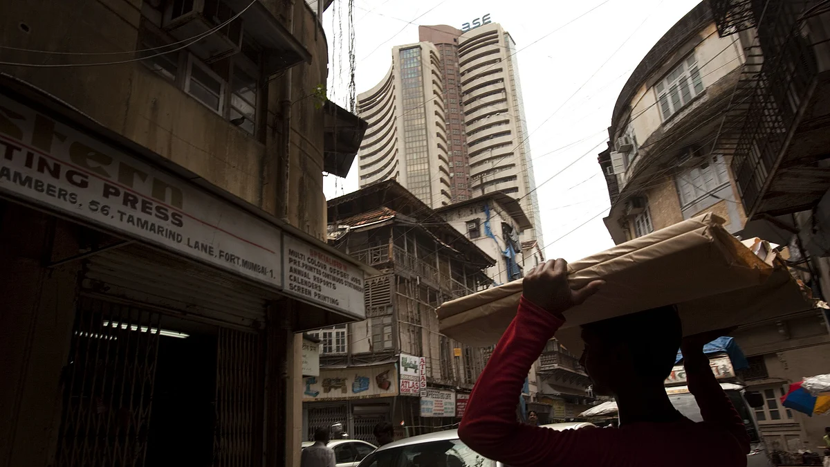 The Bombay Stock Exchange (BSE) rises in the background as people work on a corner of Mumbai. (Photographer: Prashanth Vishwanathan/Bloomberg)