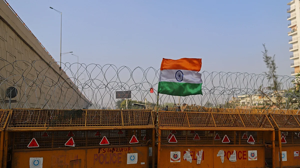 An Indian flag flies on barricades erected by the police at a highway in Ghazipur on the outskirts of New Delhi, on Feb. 6, 2021. (Photographer: Anindito Mukherjee/Bloomberg)