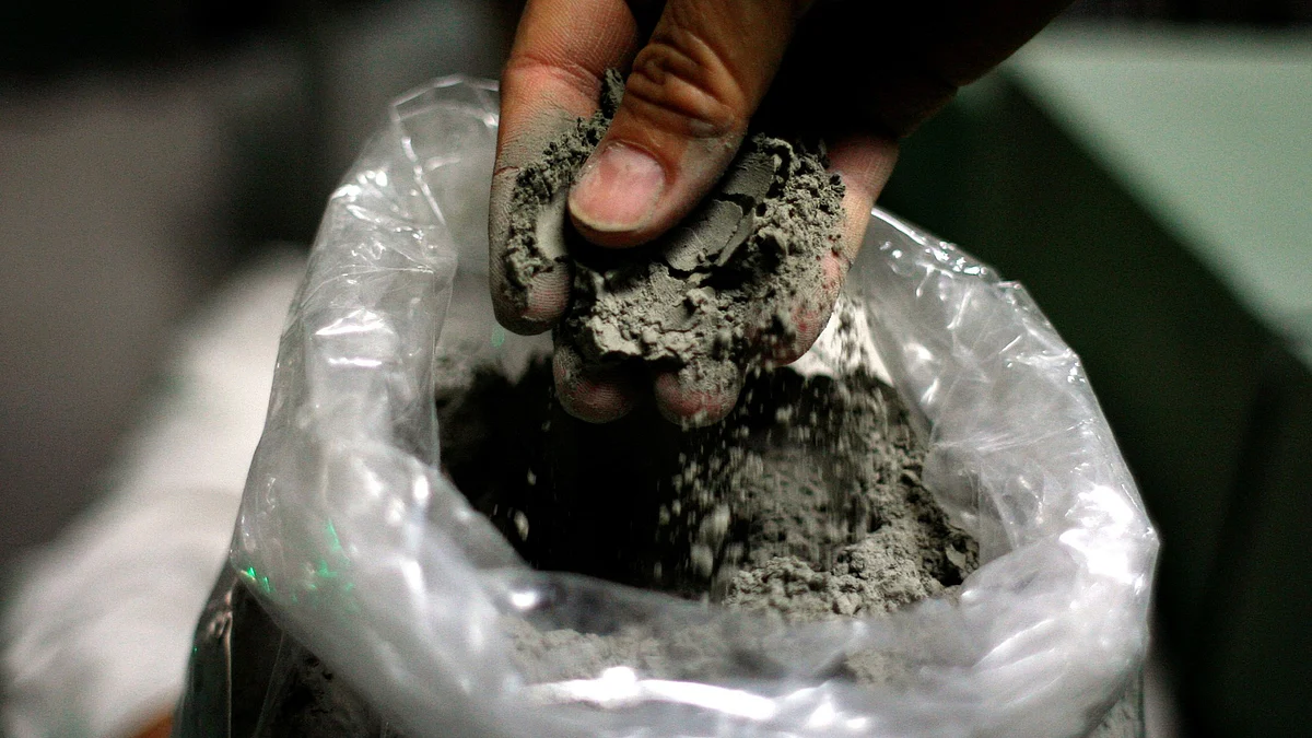 <div class="paragraphs"><p>A worker holds up processed cement at a factory. (Photographer: Dario Pignatelli/Bloomberg)</p></div>