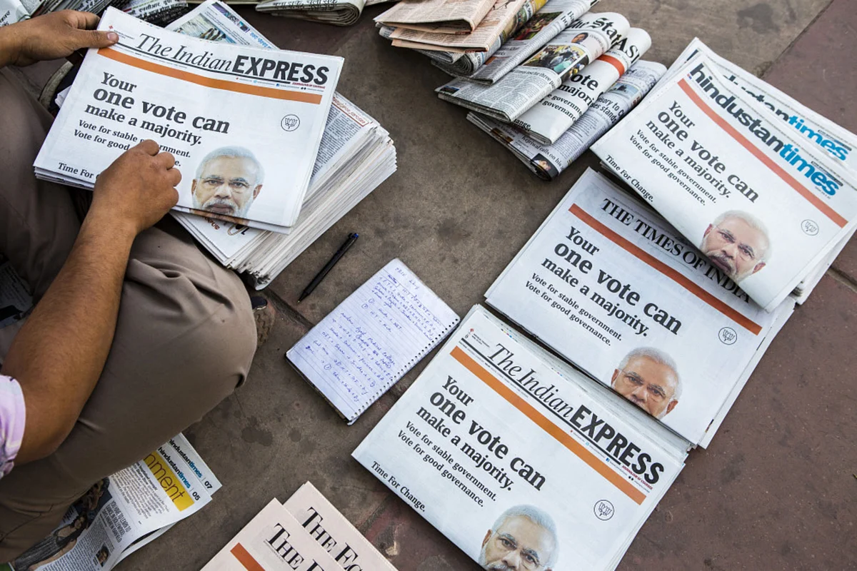 A vendor arranges copies of newspapers that feature a BJP wraparound cover advertisement ahead of voting for national elections in New Delhi, on April 10, 2014. (Photographer: Prashanth Vishwanathan/Bloomberg)