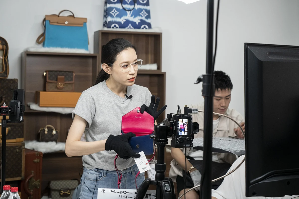 An influencer presents a handbag to the camera during a livestream event, in Beijing, on July 1, 2020. (Photographer: Giulia Marchi/Bloomberg)