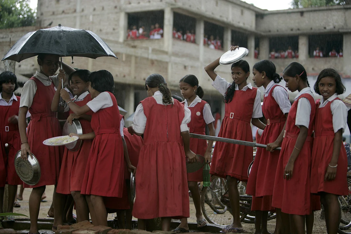 School girls gather around a hand pump to wash their food plates in Lalgarh, West Bengal. (Photographer: Adeel Halim/Bloomberg News)