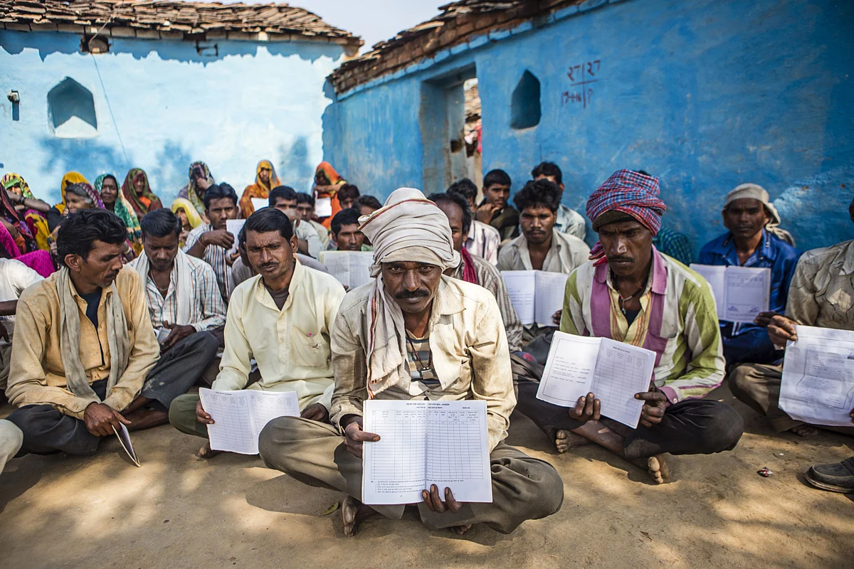 Villagers hold up their job cards with no entries for MGNREGA, during a public hearing in Tikamgarh district of Madhya Pradesh, on Feb. 8, 2016. (Photographer: Prashanth Vishwanathan/Bloomberg)