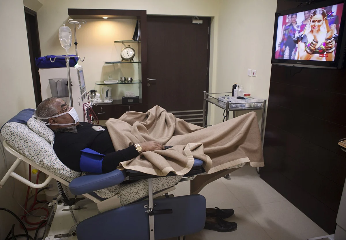 A patient watches a TV program as he undergoes dialysis, a Fortis Healthcare dialysis clinic in New Delhi. (Photographer: Prashanth Vishwanathan/Bloomberg)