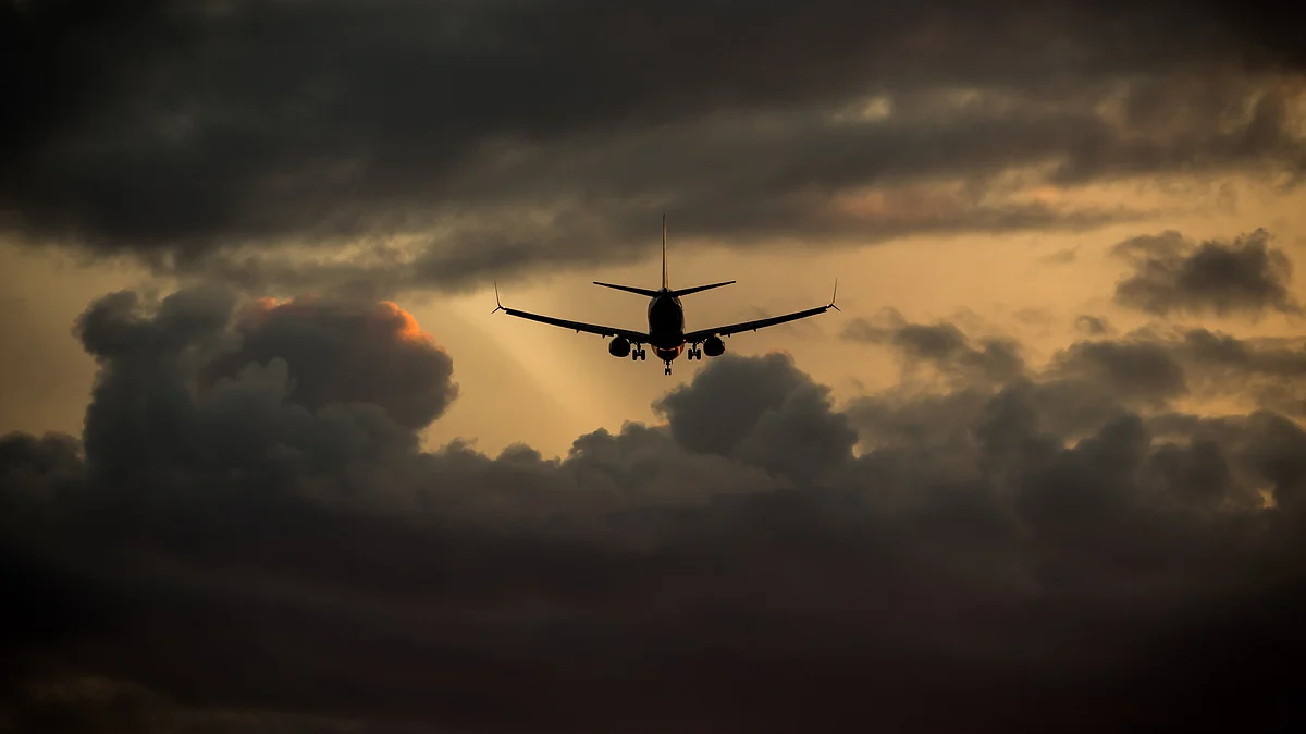An aircraft flies into the sunset. (Photographer: Darryl Dyck/Bloomberg)