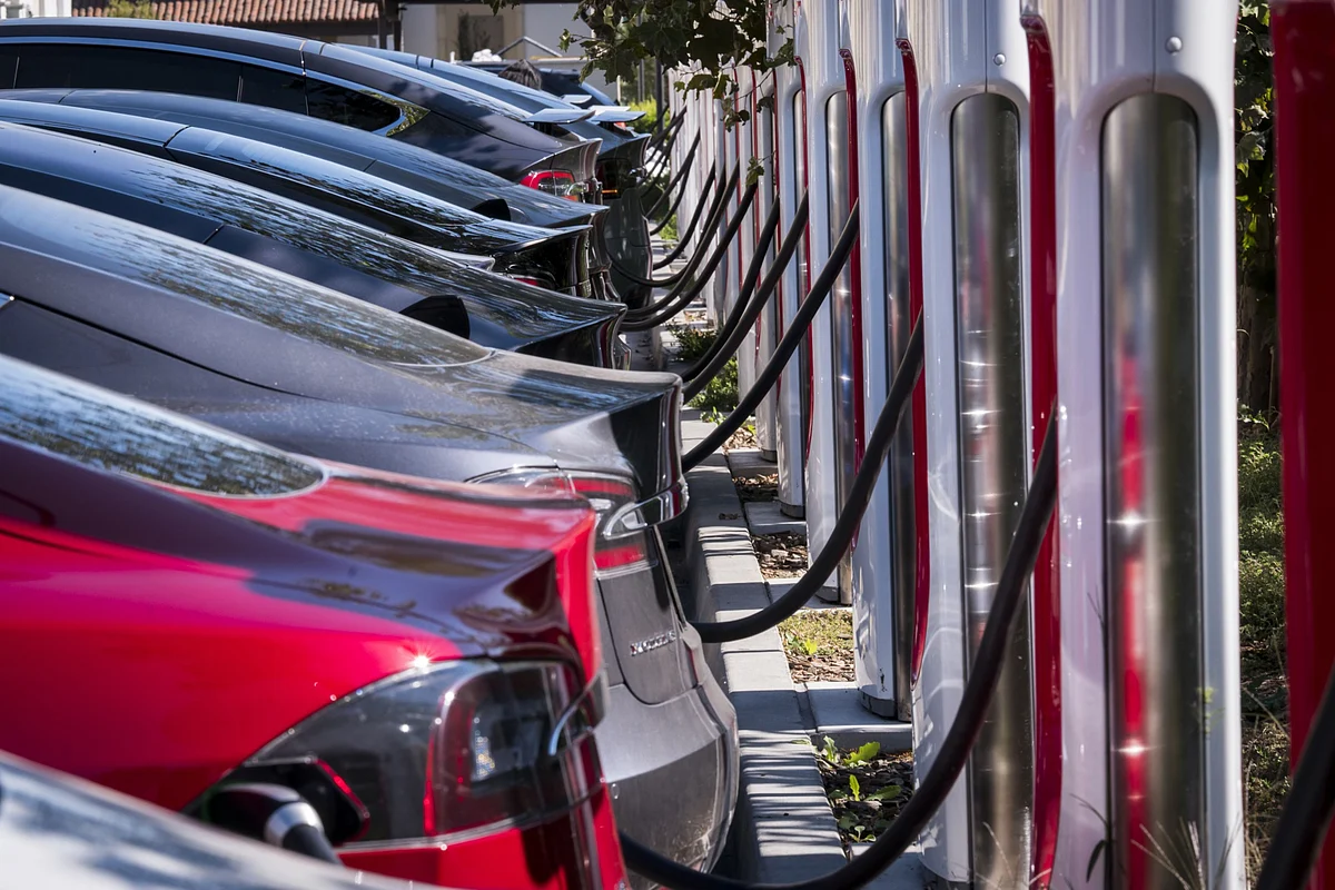 Tesla Inc. vehicles stand at a Tesla Supercharger station in Concord, California. (Photographer: David Paul Morris/Bloomberg)