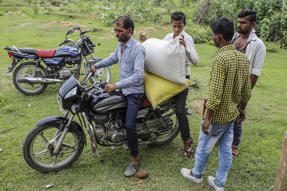 <div class="paragraphs"><p>People load a subsidized ration of grain onto a motorcycle outside a state-run distribution store in a village in Tikamgarh district, Madhya Pradesh, India. (Photographer: Dhiraj Singh/Bloomberg)</p></div>