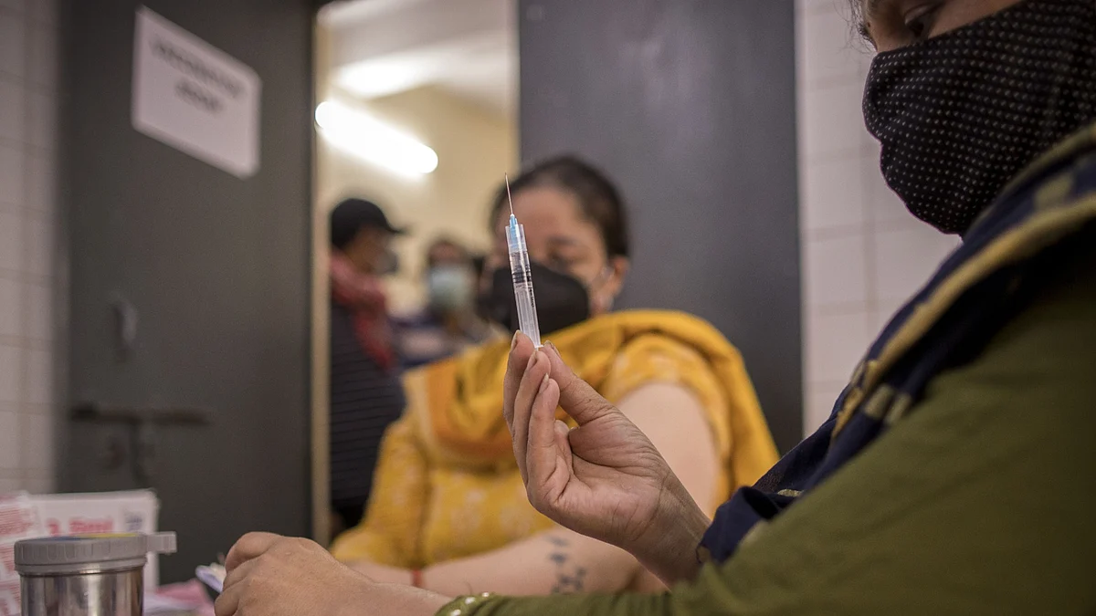 A health worker prepares a dose of Covid-19 vaccine at the heath center in the village of Bazrak, Uttar Pradesh, India (Photographer: Anindito Mukherjee/Bloomberg)