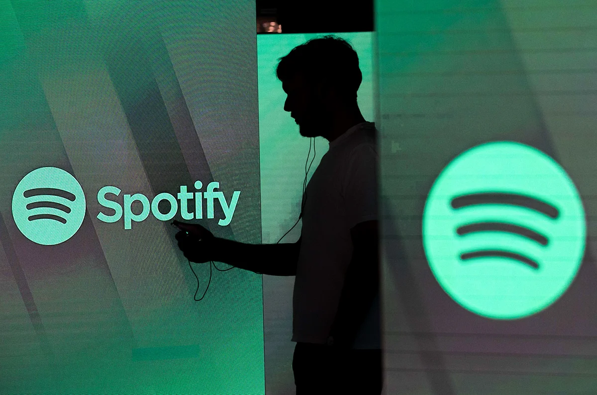 <div class="paragraphs"><p>A man checks his smartphone between screens bearing the Spotify logo, in London, on June 26, 2018. (Photographer: Chris Ratcliffe/Bloomberg)</p></div>
