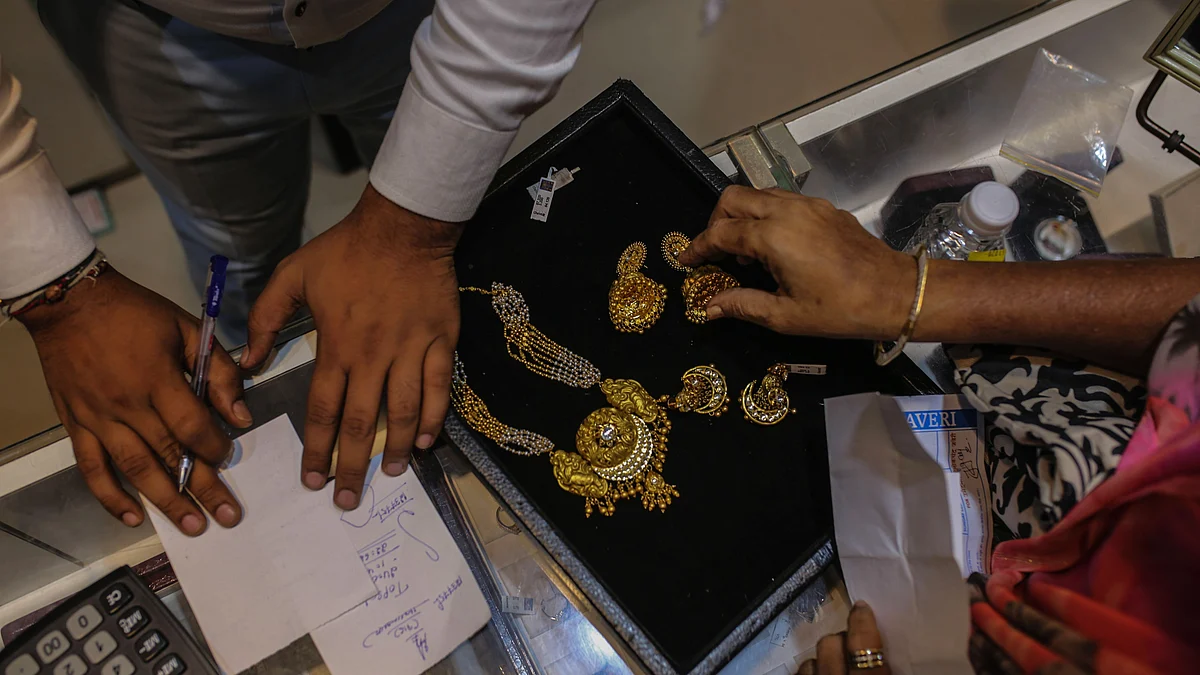 <div class="paragraphs"><p>A customer inspects gold jewelry inside a jewellery store. (Photographer: Dhiraj Singh/Bloomberg)</p></div>