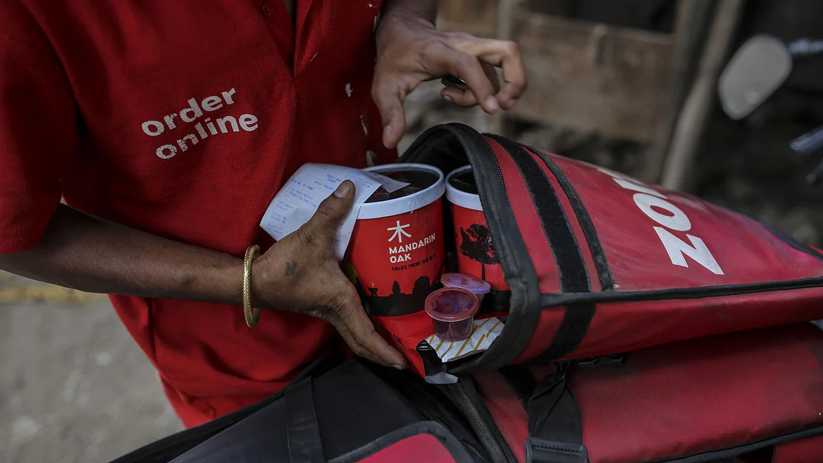 <div class="paragraphs"><p>A Zomato food courier places cartons of food into a delivery bag in Mumbai, India. (Photographer: Dhiraj Singh/Bloomberg)</p></div>