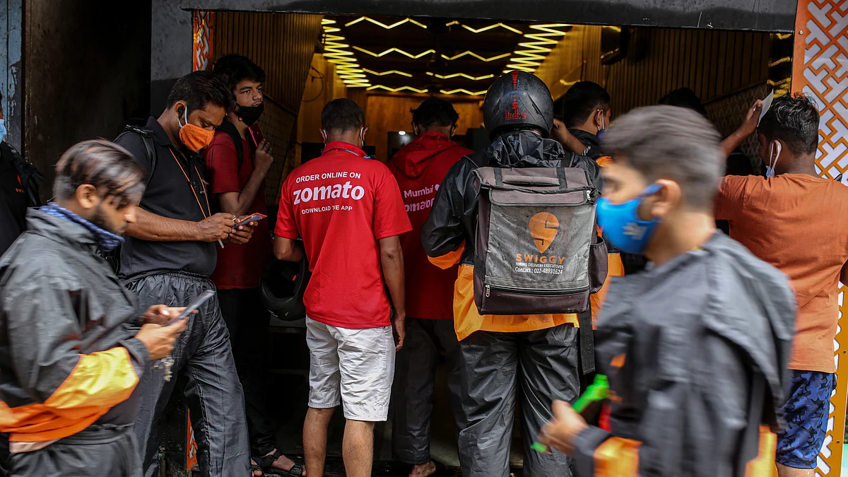 <div class="paragraphs"><p>Delivery riders for Zomato Ltd., center, and Swiggy, operated by Bundl Technologies Pvt., wait to collect orders outside a restaurant in Mumbai. (Photographer: Dhiraj Singh/Bloomberg)</p></div>