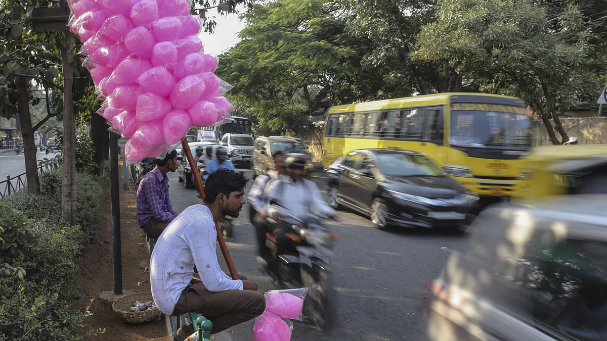 <div class="paragraphs"><p>A vendor holds a stick displaying cotton candy for sale as traffic moves a long a road in Bangalore, India. (Photographer: Dhiraj Singh/Bloomberg)</p></div>