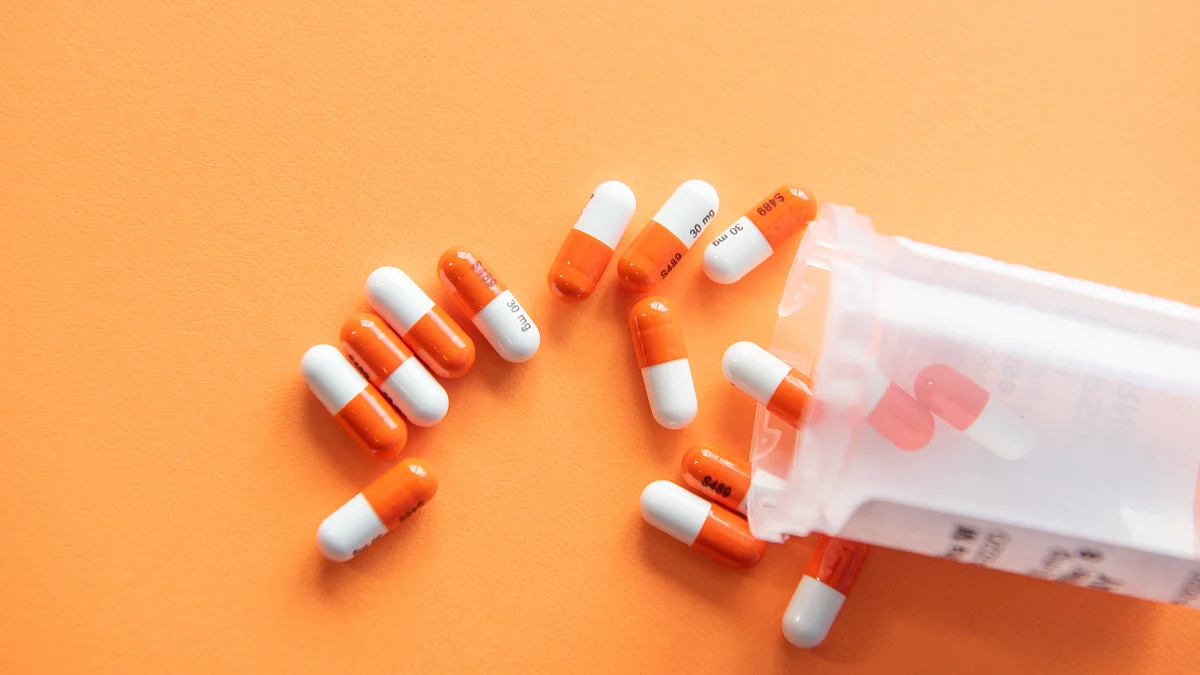 <div class="paragraphs"><p>Prescription drugs on an orange background with a pill bottle. (Source: Christina Victoria Craft/Unsplash)</p></div>