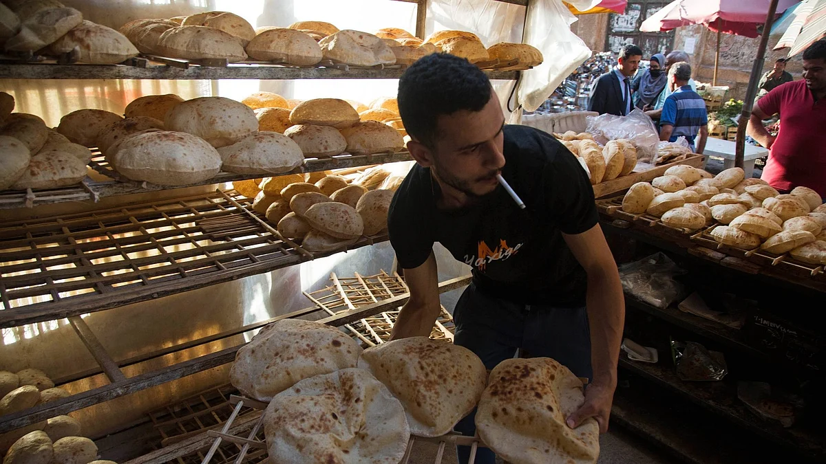 <div class="paragraphs"><p>A worker arranges freshly baked bread for sale at the Al-Monira market in Cairo, Egypt, on Wednesday, June 1, 2022.</p></div>