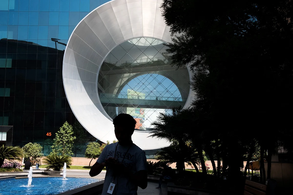 <div class="paragraphs"><p>An employee is silhouetted as he walks past a water feature at Building 44 of the Infosys Ltd. campus in Bengaluru</p></div>