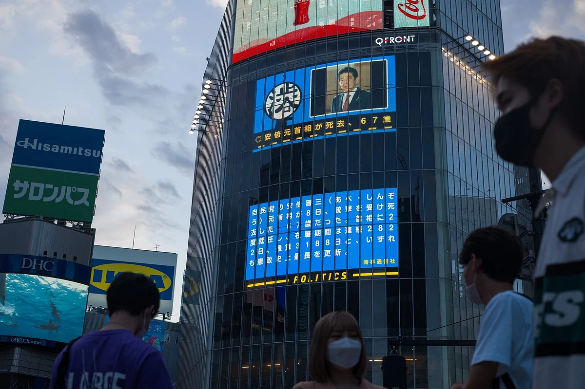 A news report on former Japanese Prime Minister Shinzo Abe died after being shot during a campaign event in Nara, displayed on a screen in the Shibuya district of Tokyo, Japan, on Friday, July 8, 2022 Photographer: Kentaro Takahashi/Bloomberg