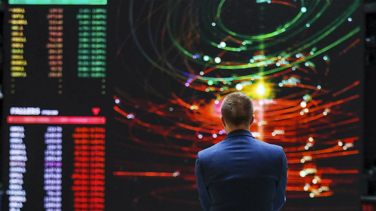 An employee views a FTSE share index board in the atrium of the London Stock Exchange Group Plc's offices in London.