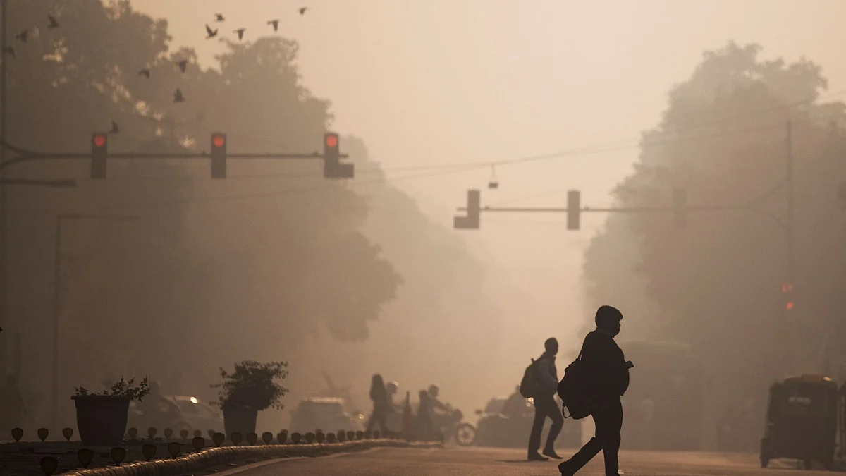 Commuters cross a street amid smoggy conditions in New Delhi Photographer: Jewel Samad/AFP/Getty Images