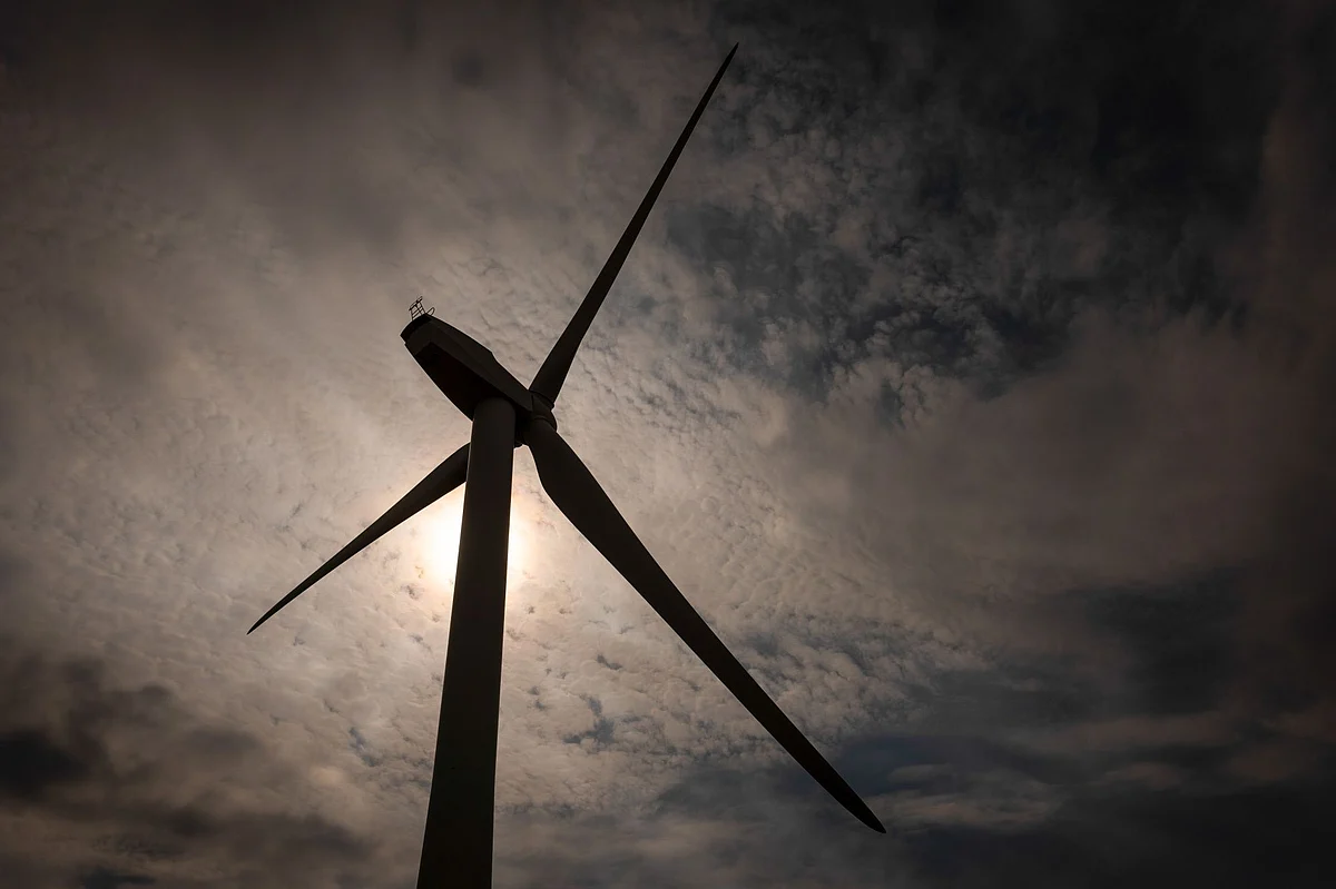 A wind turbine on the Red Tile Wind Farm near Cambridge, UK, on Monday, Aug. 15, 2022. Like soldiers in an electron battlefield, EVs en masse are great for storing renewable electricity and sending it back to the grid during peak demand. Photographer: Jose Sarmento Matos/Bloomberg