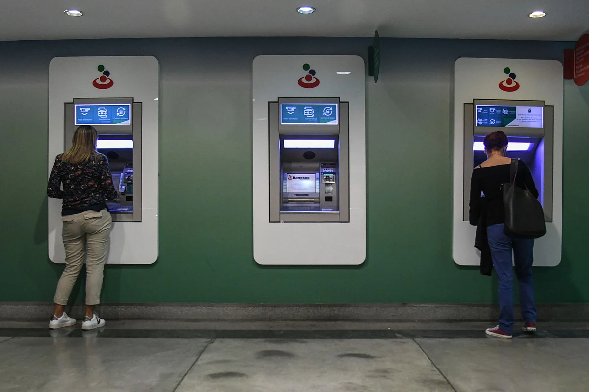 <div class="paragraphs"><p>Residents withdraw new bolivar banknotes from an automated teller machine (ATM) at Banesco Banco Universal headquarters.</p></div>