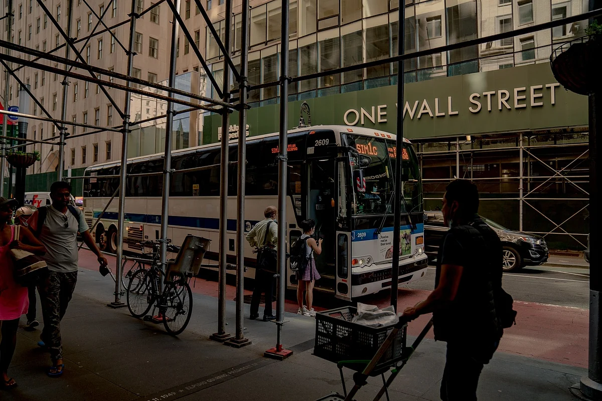 <div class="paragraphs"><p>Commuters board a bus in front of One Wall Street in New York. (Photo: Amir Hamja/Bloomberg)</p></div>