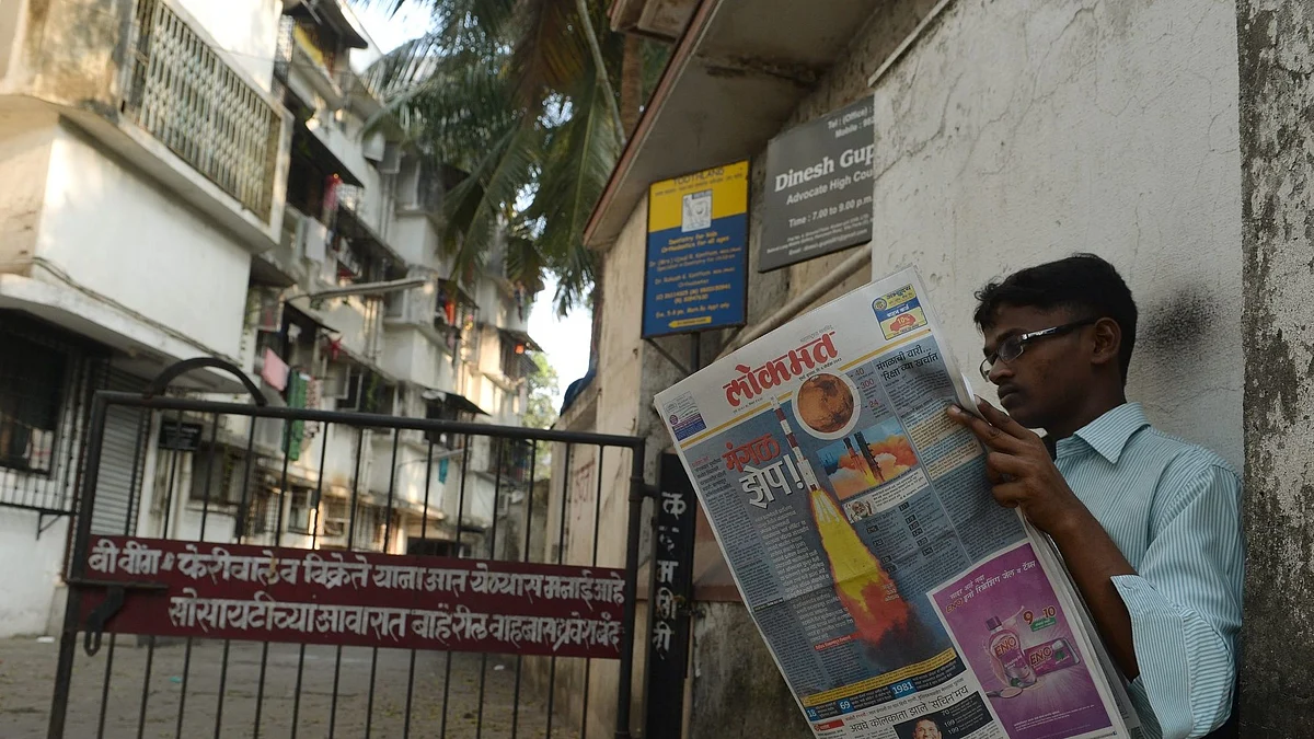 A man reads a newspaper showing the story of the country's Mars Orbiter Mission launch in 2013. Photographer: Punit Paranjpe/AFP/Getty Images