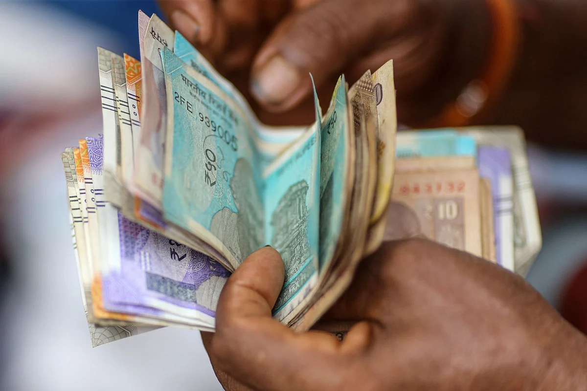 <div class="paragraphs"><p>A delivery worker counts Indian rupee banknotes in Mumbai, India. (Photo: Dhiraj Singh/Bloomberg)</p></div>