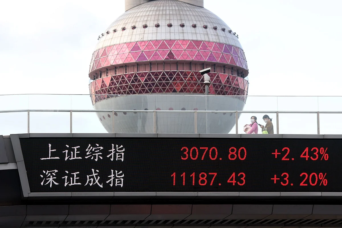 SHANGHAI, CHINA - NOVEMBER 04: People walk on a pedestrian bridge which displays the numbers for the Shanghai Shenzhen stock indexes on November 04, 2022 in Shanghai, China. (Photo by Hugo Hu/Getty Images)
