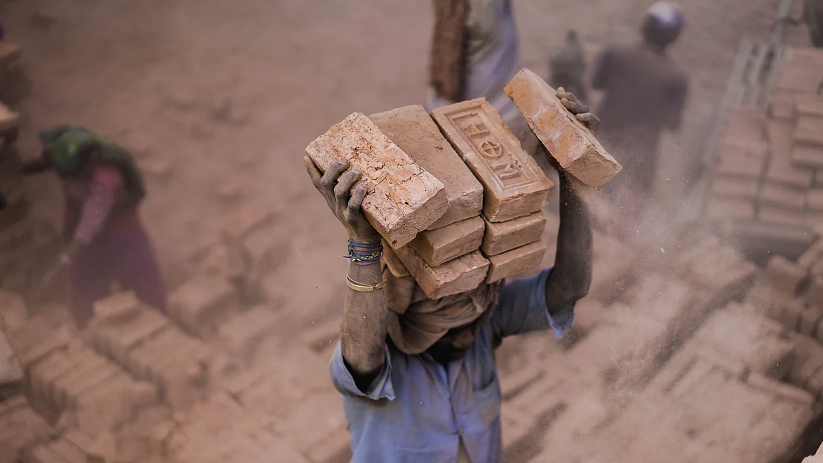 <div class="paragraphs"><p>A labour carrying bricks on head at a construction site. (Photo: Safal Karki/ Unsplash)</p></div>