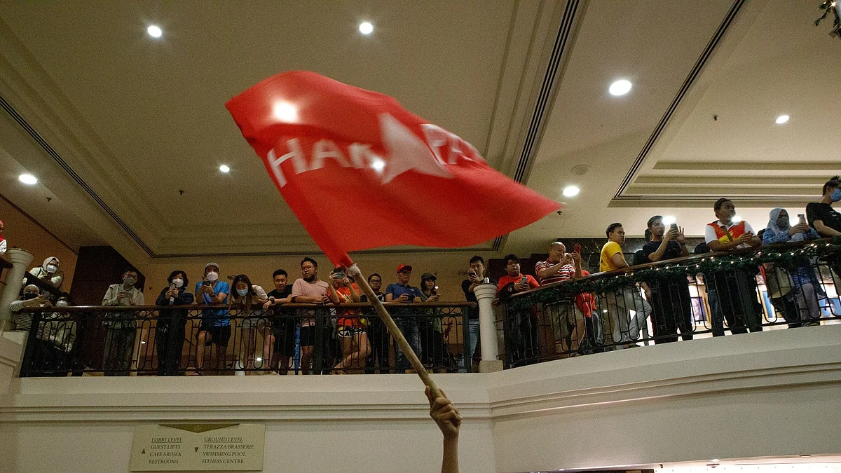 Supporters of the Pakatan Harapan (PH) party wave a flag at an election event in Subang, Malaysia, on Sunday, Nov. 20, 2022. Malaysia is heading for its first-ever hung parliament as coalitions led by Prime Minister Ismail Sabri Yaakob, opposition leader Anwar Ibrahim and former premier Muhyiddin Yassin are poised to fail to win a majority, fueling political uncertainty in an economy on a fragile rebound.