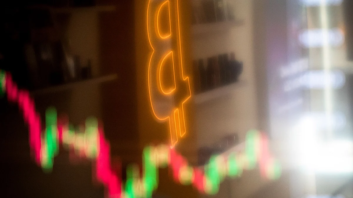 A reflection of a candlestick price chart and an illuminated Bitcoin logo inside a BitBase cryptocurrency exchange in Barcelona, Spain, on Monday, May 16, 2022. The wipeout of algorithmic stablecoin TerraUSD and its sister token Luna knocked more than $270 billion off the crypto sector’s total trillion-dollar value in the most volatile week for Bitcoin trading in at least two years. Photographer: Angel Garcia/Bloomberg