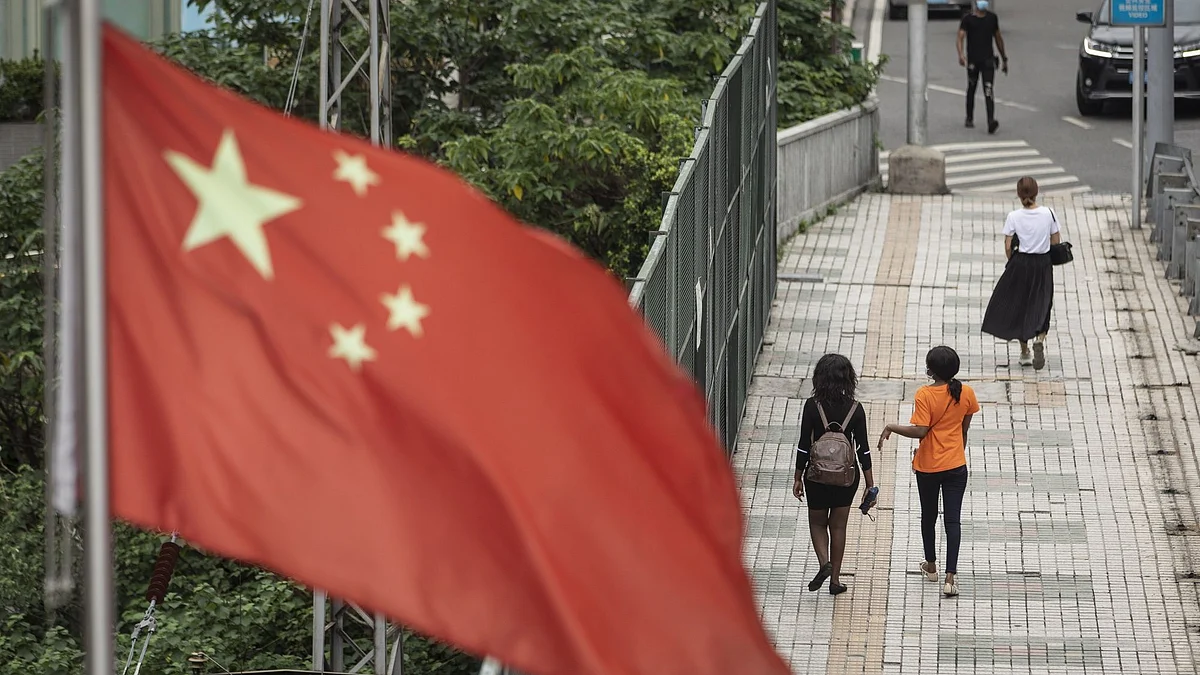<div class="paragraphs"><p>Pedestrians walk down a street as a Chinese flag flies near a wholesale mall in Guangzhou, China, on Thursday, May 14, 2020. Photographer: Qilai Shen/Bloomberg</p></div>