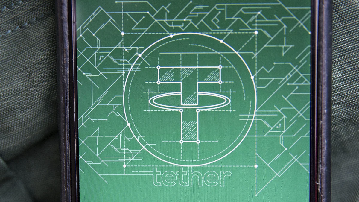 <div class="paragraphs"><p>The Tether logo is seen on a smartphone in this arranged photograph taken in Washington, D.C., U.S. (Photographer: Andrew Harrer/Bloomberg)</p></div>