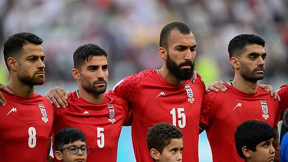 DOHA, QATAR - NOVEMBER 21: (L-R) Morteza Pouraliganji, Milad Mohammadi and Roozbeh Cheshmi of IR Iran line up for the national anthem prior to the FIFA World Cup Qatar 2022 Group B match between England and IR Iran at Khalifa International Stadium on November 21, 2022 in Doha, Qatar. (Photo by Matthias Hangst/Getty Images)