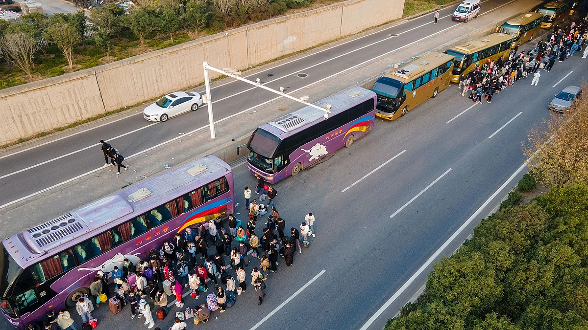 Foxconn employees take shuttle buses to head home on October 30, 2022 in Zhengzhou, Henan Province of China. Shuttle buses have been arranged by local authorities to facilitate the return trips of Foxconn factory workers to their hometowns after COVID-19 infections were reported in the city Zhengzhou. Photographer: VCG/Getty Images